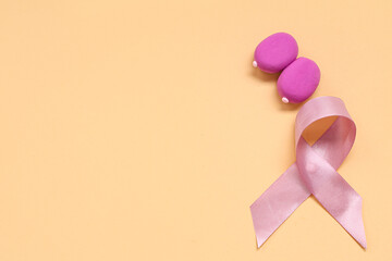 Female breast made of play dough and pink ribbon on color background. Breast cancer awareness concept