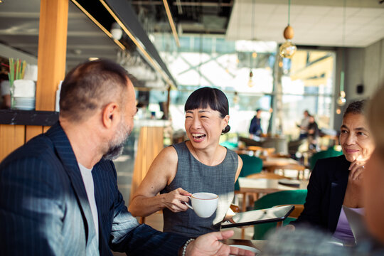 Diverse business people having meeting in modern cafe - Powered by Adobe