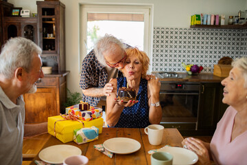 Senior woman celebrating birthday with friends at home