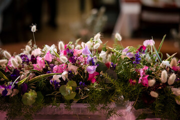 Beautiful purple, pink and white rows of flowers at wedding head table