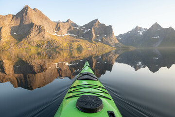 The reflection of the mountains in a lake during a kayaking session at sunset. 