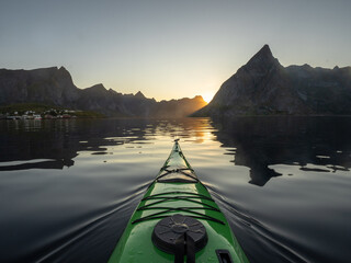 A sunset paddle on a fjord surrounded by mountains at sunset in Norway. 