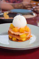 Close up view of beautifully plated ice cream dessert with apricots in restaurant