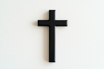 Black cross is hanging on a white wall