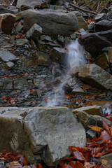 A small waterfall between stones outside.
