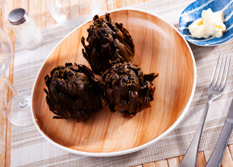 Baked artichokes with spices on plate, tasty vegetables for dinner
