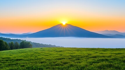 Serene Sunrise over Mountain Landscape with Fog and Green Grass