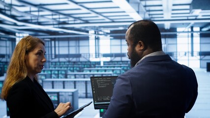 Teamworking coworkers doing maintenance using devices, prolonging data center hardware life span....