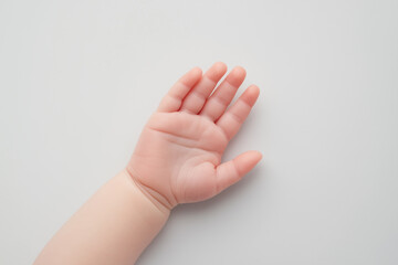 baby hand reaching out, symbolizing innocence and curiosity.