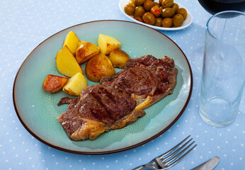 Portion of fried potatoes with beef tenderloin steak