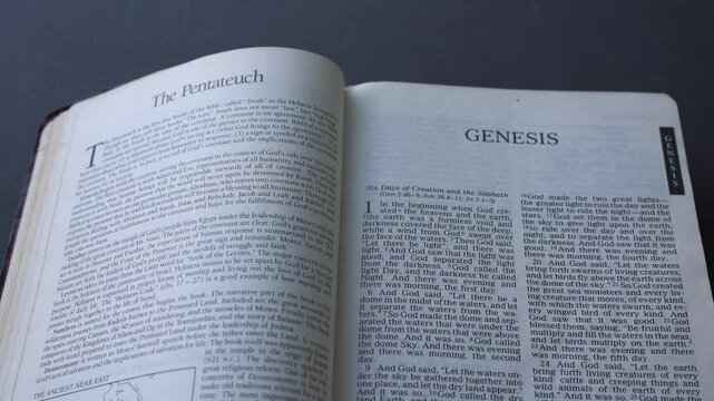 Book of Genesis Chapter 1 of the Holy Bible, open up on the table, first line starting with In the beginning. Passage on the creation.