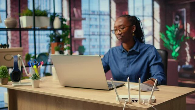 Irritated African American girl struggling to reach the internet provider to help fix the signal loss issues, freelancer working at home with an unstable Wi Fi connection. Camera A.