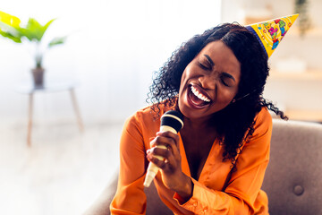 Birthday Fun. African American Woman Singing Song With Eyes Closed Holding Microphone Having...