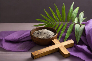 Holy Week, Lent, Palm Sunday, Good Friday, Easter Sunday Concept. Cross, palm leaf, ashes, purple fabric with copy space background.