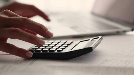 Asian senior woman calculates bills Use calculator to carry out company financial and accounting senior Women hand using calculator on desk