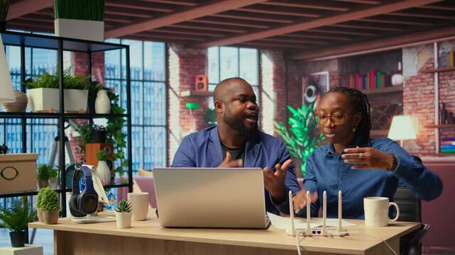 Angry African American people tries to reset the Wi Fi modem due to signal loss, woman arguing and being irritated. Frustrated couple fighting over troubleshooting methods. Camera A.