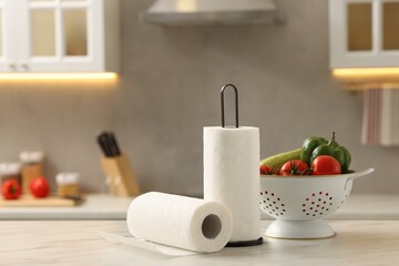 Rolls of paper towels and vegetables on white marble table in kitchen