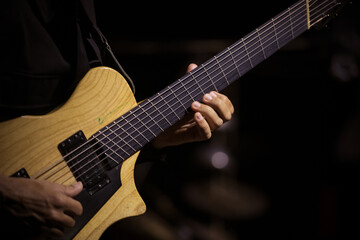 Detailed shot of a musician's hand playing electric guitar in a jazz concert.