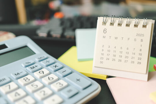 Desk calendar for JUNE 2025 with Sticky note. Calendar concept with 2025 JUN calendar. calculator and forecast for finances in 2025. Money, Budget, tax, investment and financial.