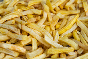 Food background of potato fry. Fried potato. Crispy golden French fries. French fries background. Street fast food. Junk food cuisine