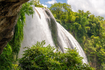 Obraz premium The waterfall interrupts violently the peaceful continuous flow of the river's water