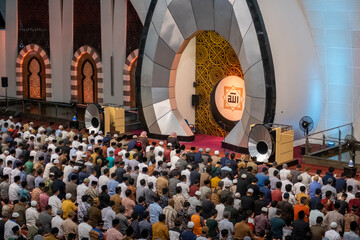 A group of Muslims praying together in the Grand Mosque of West Sumatra with a luxurious and...