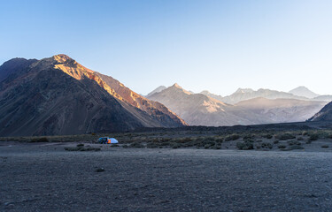 Camping tent at sunrise in the Andes mountains, Chile Scenic wilderness landscape with dramatic peaks, perfect for travel, adventure and outdoor lifestyle concepts
