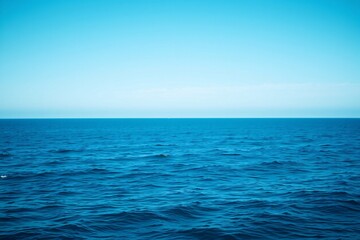 Obraz premium Tranquil view of an endless blue ocean meeting the bright, clear sky, conveying peace and serenity.
