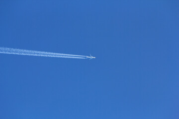 青空の中を飛ぶ飛行機と飛行機雲 Plane and contrail flying in the blue sky