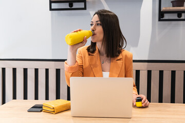 Healthy habit to drink water. Business woman drinking water from bottle and using laptop. Control body hydration, Tracker water balance