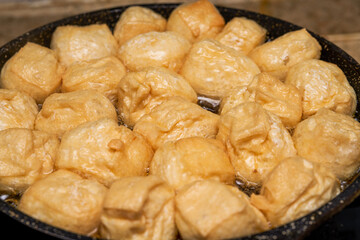 A chef is frying tofu in a pan in the kitchen