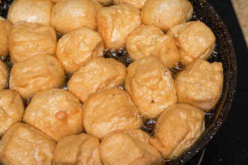 A chef is frying tofu in a pan in the kitchen