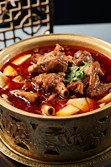 Spicy lamb shank and lamb knee bone stewed in red oil in copper pot