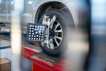 Wheel Alignment Check:  A close-up shot of a car wheel undergoing a precise wheel alignment check using specialized equipment in an auto repair shop.