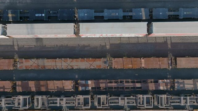High-angle view of multiple freight train cars on tracks. Various types of cars, some rusty, are seen. Transportation of goods. PENROSE, AUCKLAND, NZ
