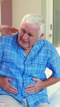Suffering senior man holding his belly