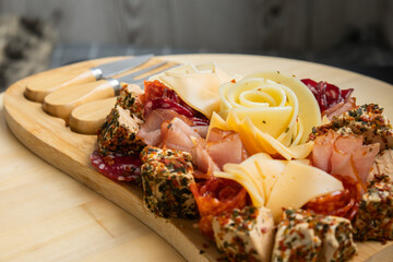Food trend gift aperitivo party idea. Appetizers wooden grazing board with different antipasti charcuterie snacks and cheese. Assorted cheese meat platter. Disordered eating. Girl dinner