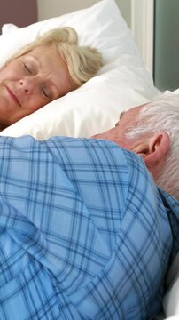 Senior couple sleeping in bed