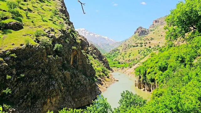 Lush green valley with a winding river, framed by towering mountains under a bright sky.
📍Selin, Hawraman Takht - Kurdistan 