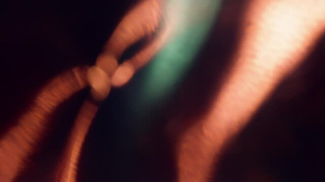 Blur abstract light. Optical lens flare. Golden green bright colorful sparkling blinking gleaming flickers on dark art background.