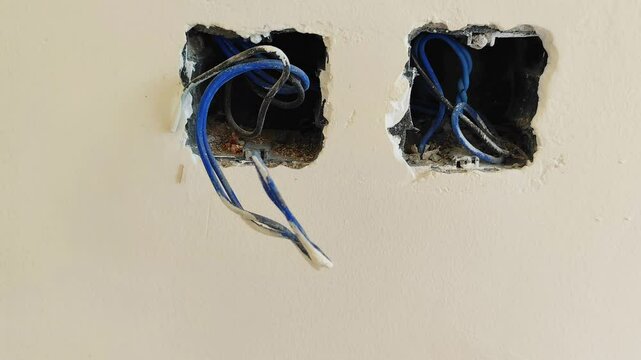 Electrical wiring installation process with visible cables and power outlets in a building under construction, showcasing the essential infrastructure setup for electricity in modern property