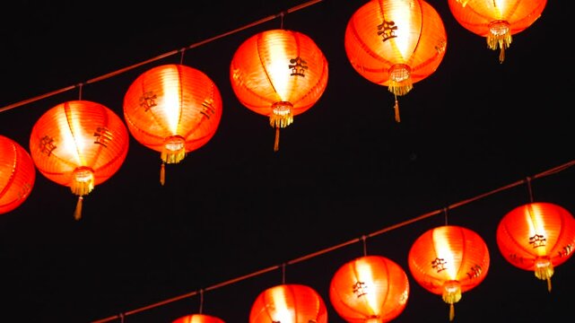 Rows of red paper lanterns glow at night during Chinese New Year