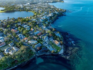 Coastal suburbia, stunning homes, and a tranquil bay. Aerial view of waterfront properties. TAKAPUNA, AUCKLAND, NZ