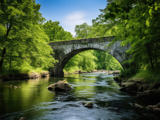 Fototapeta premium Tranquil River Scene with Ancient Arch Bridge