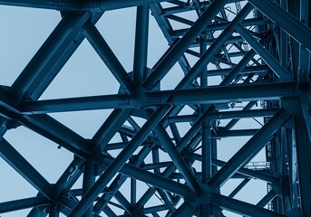 Steel Structure Framework Intersecting in Geometric Patterns Against Pale Blue Sky