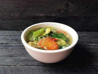Vegetables soup in white bowl on black wooden table background. Healthy food lifestyle 