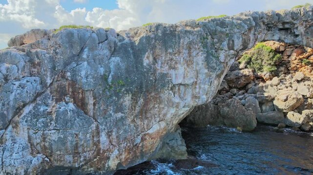 Discover the natural beauty of Cala Varques, featuring a breathtaking rock arch surrounded by clear blue waters and rugged cliffs. This serene location is perfect for nature lovers.
