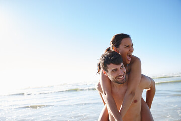 Love, beach and couple piggyback with smile, vacation and date by sea for romance and affection....
