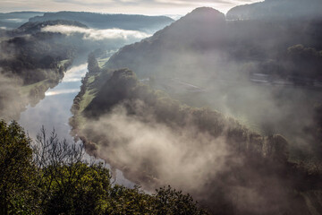 Rivière dans une vallée embrumée au lever du jour