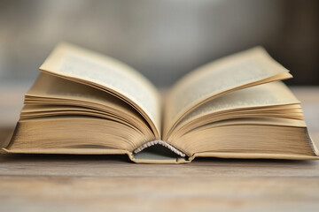 A Minimalist Open Book on a Light Wooden Table, Ready for New Words.
